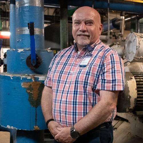 Color photo of Harold Turner standing in mechanical room.